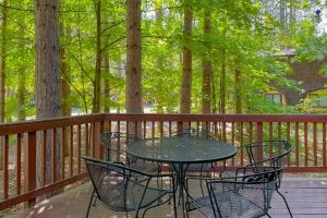a table and chairs on a deck with trees at Crystal Haven in Thompsonville