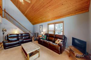 a living room with leather furniture and a wooden ceiling at Crystal Haven in Thompsonville