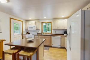 a kitchen with white appliances and a wooden table at The Rootskeller in Oak Bluffs