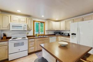 a kitchen with white appliances and wooden cabinets at The Rootskeller in Oak Bluffs