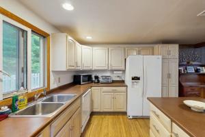 a kitchen with white cabinets and a white refrigerator at The Rootskeller in Oak Bluffs