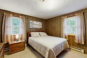 a bedroom with a bed and two windows at The Rootskeller in Oak Bluffs +11 photos