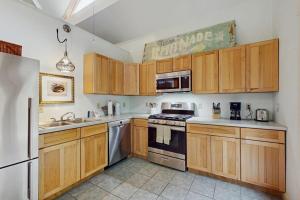 a kitchen with wooden cabinets and stainless steel appliances at The Lemonade Stand in West Tisbury