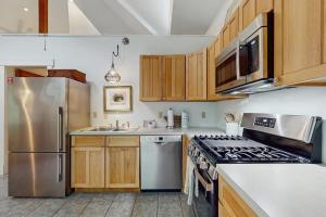 a kitchen with stainless steel appliances and wooden cabinets at The Lemonade Stand in West Tisbury +9 photos