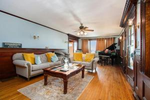 a living room with a couch and a table and a piano at Lake Michigan Retreat- Upper Duplex in Benton Harbor