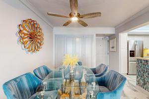 a dining room with blue chairs and a glass table at Waves & Palms Oasis in Marco Island
