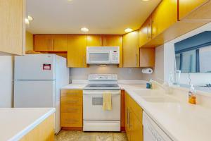 a kitchen with white appliances and wooden cabinets at Sea Colony --- 1BB Brandywine Garden in Bethany Beach +38 photos
