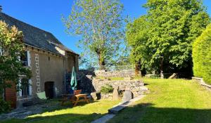 a garden with a bench and a building at Le Refuge de l'Argence in Alpuech