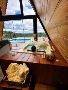 a person laying in a bath tub in a room at Chalés La Montagna in Santa Teresa +22 photos