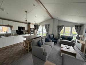 a kitchen and living room with couches and a table at Luxury 3 bed lodge, Skegness - East Coast Holidays in Winthorpe