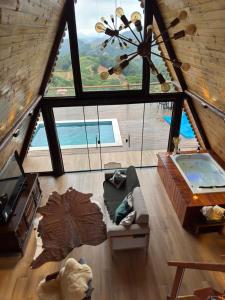 a living room with a large window and a couch at Chalés La Montagna in Santa Teresa