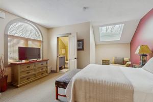 a bedroom with a bed and a flat screen tv at WinterGreen Condo, #522 in Thompsonville +7 photos