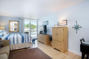 a bedroom with a bed and a dresser and a television at Waterside Suites in Saugatuck