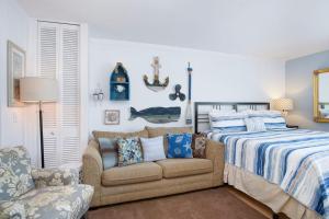 a bedroom with a bed and a couch and a chair at Waterside Suites in Saugatuck