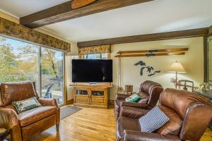 ein Wohnzimmer mit Ledermöbeln und einem Flachbildfernseher in der Unterkunft Riverside Abode in Thompsonville