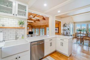 a kitchen with white cabinets and a dining room at Birchwood: Meadows Bliss in Harbor Springs