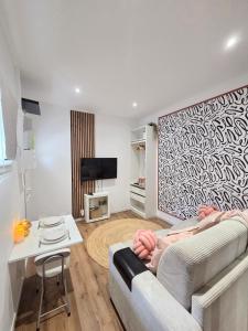 a living room with a couch and a table at Le Charme Rosé in Villejuif