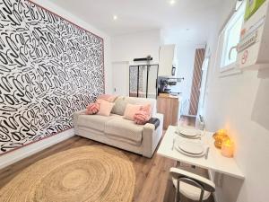 a living room with a couch and a table at Le Charme Rosé in Villejuif