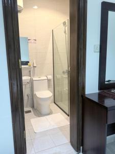 a bathroom with a toilet and a glass shower at بستان الورد 2 in Taif