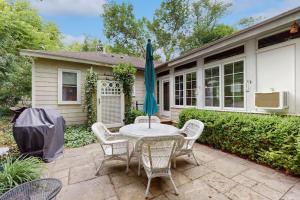 a patio with a table and chairs and an umbrella at Happy Thoughts Cottage in New Buffalo