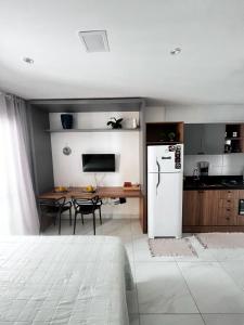 a kitchen with a white refrigerator and a table at Laguna beach house in Cabedelo