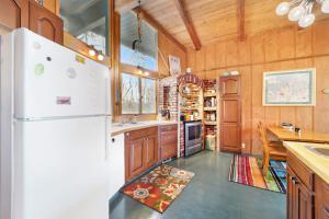 a kitchen with a white refrigerator and wooden walls at Petoskey Stone Lodge in Bellaire +16 photos
