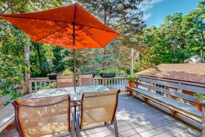 a table and chairs with an umbrella on a deck at Private Pocasset Getaway in Pocasset