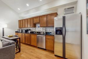 a kitchen with a stainless steel refrigerator and wooden cabinets at Arrowhead Resort - Undeniably Darling in Saugatuck
