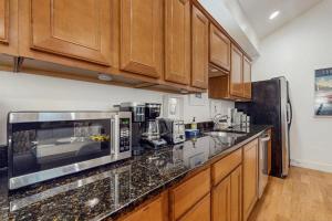a kitchen with a counter top with a microwave at Arrowhead Resort - Undeniably Darling in Saugatuck