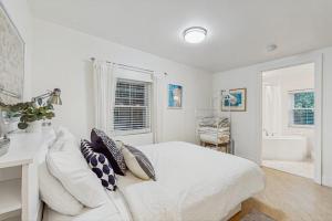 a white bedroom with a bed and a bath tub at Arrowhead Resort - Undeniably Darling in Saugatuck