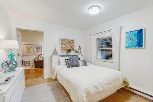 a white bedroom with a bed and a window at Arrowhead Resort - Undeniably Darling in Saugatuck +6 photos