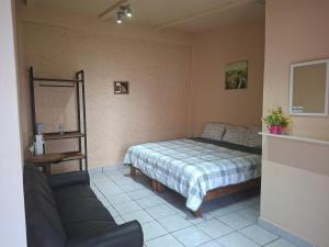 a small bedroom with a bed and a couch at Hotel Casa del virrey Atlixco in Atlixco