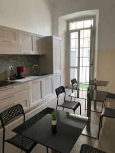 a kitchen with white cabinets and chairs and a table at Viva Accomodation in Bergamo