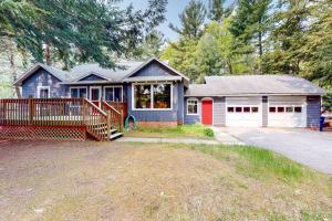 a small blue house with a white garage at Wanderlust in Glen Arbor