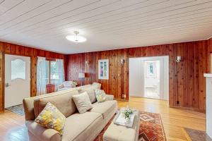 a living room with a couch and wooden walls at Wanderlust in Glen Arbor