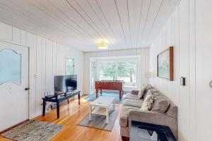 a living room with a couch and a flat screen tv at Wanderlust in Glen Arbor +16 photos