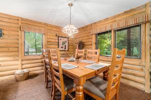 a dining room with a wooden table and chairs at The Log Cabin in Thompsonville