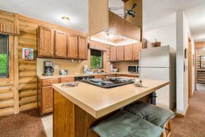 a kitchen with wooden cabinets and a white refrigerator at The Log Cabin in Thompsonville