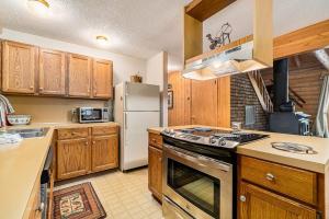 a kitchen with wooden cabinets and a white refrigerator at The Log Cabin in Thompsonville +29 photos