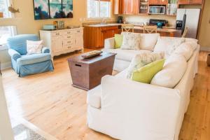 a living room with two white couches and a kitchen at Sunshine Villa in Union Pier