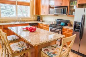 a kitchen with wooden cabinets and a kitchen island with chairs at Sunshine Villa in Union Pier