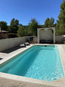 a swimming pool in a yard with a patio at Boutique B&B Masia Katmandú in Cretas