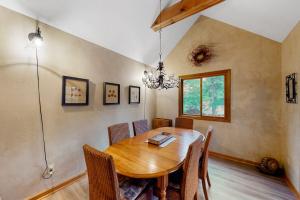 a dining room with a wooden table and chairs at Creeping Snails in Glen Arbor +13 photos