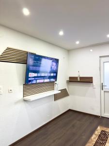 a large flat screen tv on a wall in a room at MIO plus Apartments Sulzbach in Sulzbach