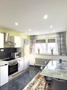 a kitchen with white appliances and a table with chairs at MIO plus Apartments Sulzbach in Sulzbach