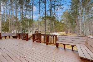 two benches sitting on a wooden deck in the woods at Crystal Mountain Retreat in Thompsonville