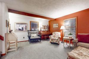a living room with a chair and a piano at Crystal Mountain Retreat in Thompsonville