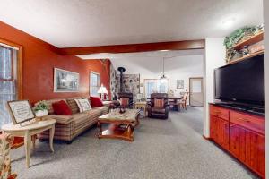 a living room with a couch and a flat screen tv at Crystal Mountain Retreat in Thompsonville