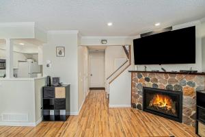 a living room with a fireplace with a flat screen tv at Hideaway Valley Condo 36 in Harbor Springs