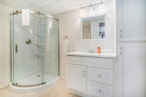 a white bathroom with a shower and a sink at Hideaway Valley Condo 36 in Harbor Springs +28 photos